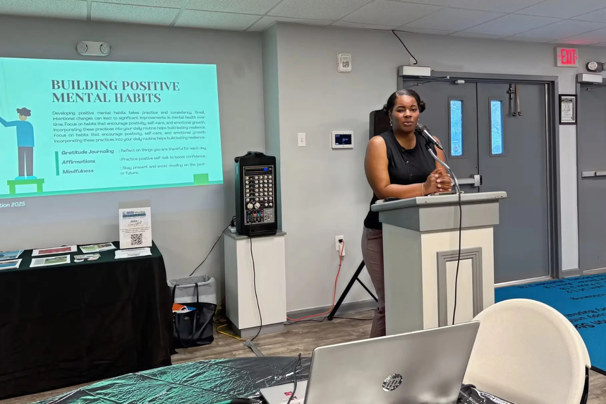 Speaker presenting on mental health awareness at a God's Will Foundation community workshop.