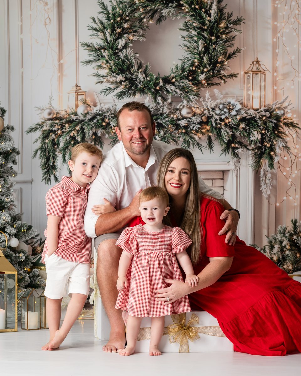 A gentle festive portrait of a child with her cuddly soft dog with Christmas tree at the back