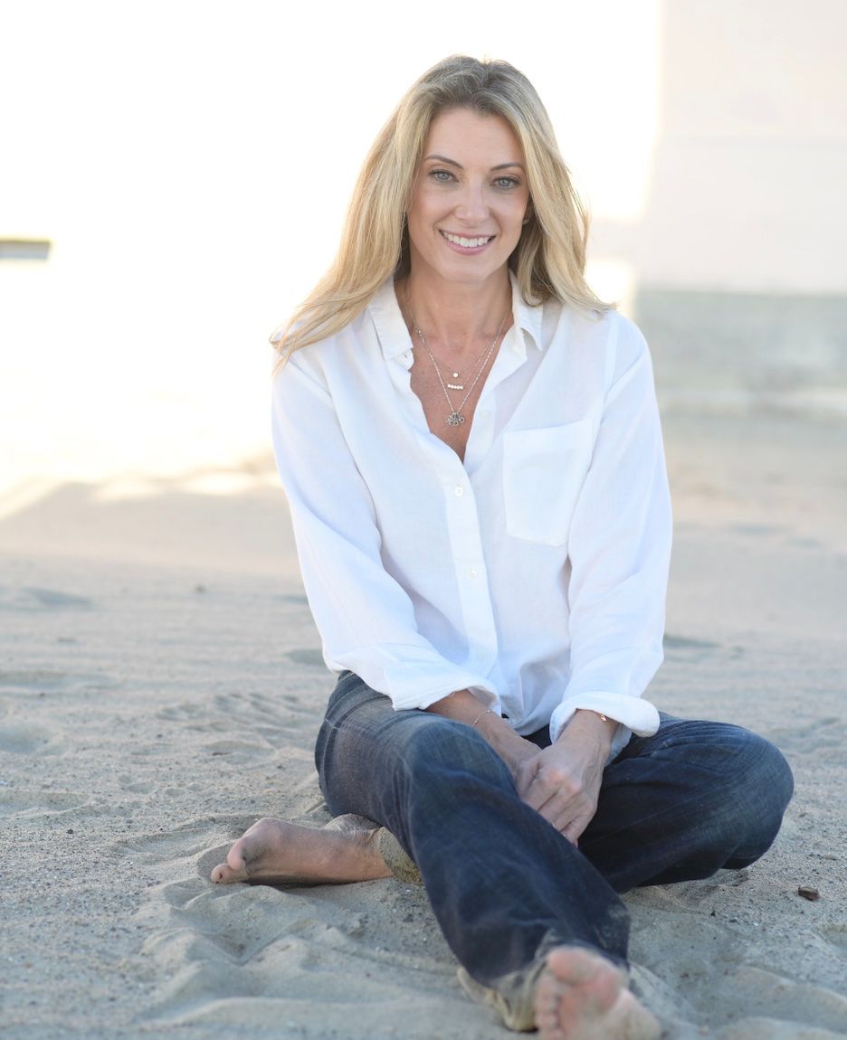 Lisa Miller, relationship coach, sitting on the beach