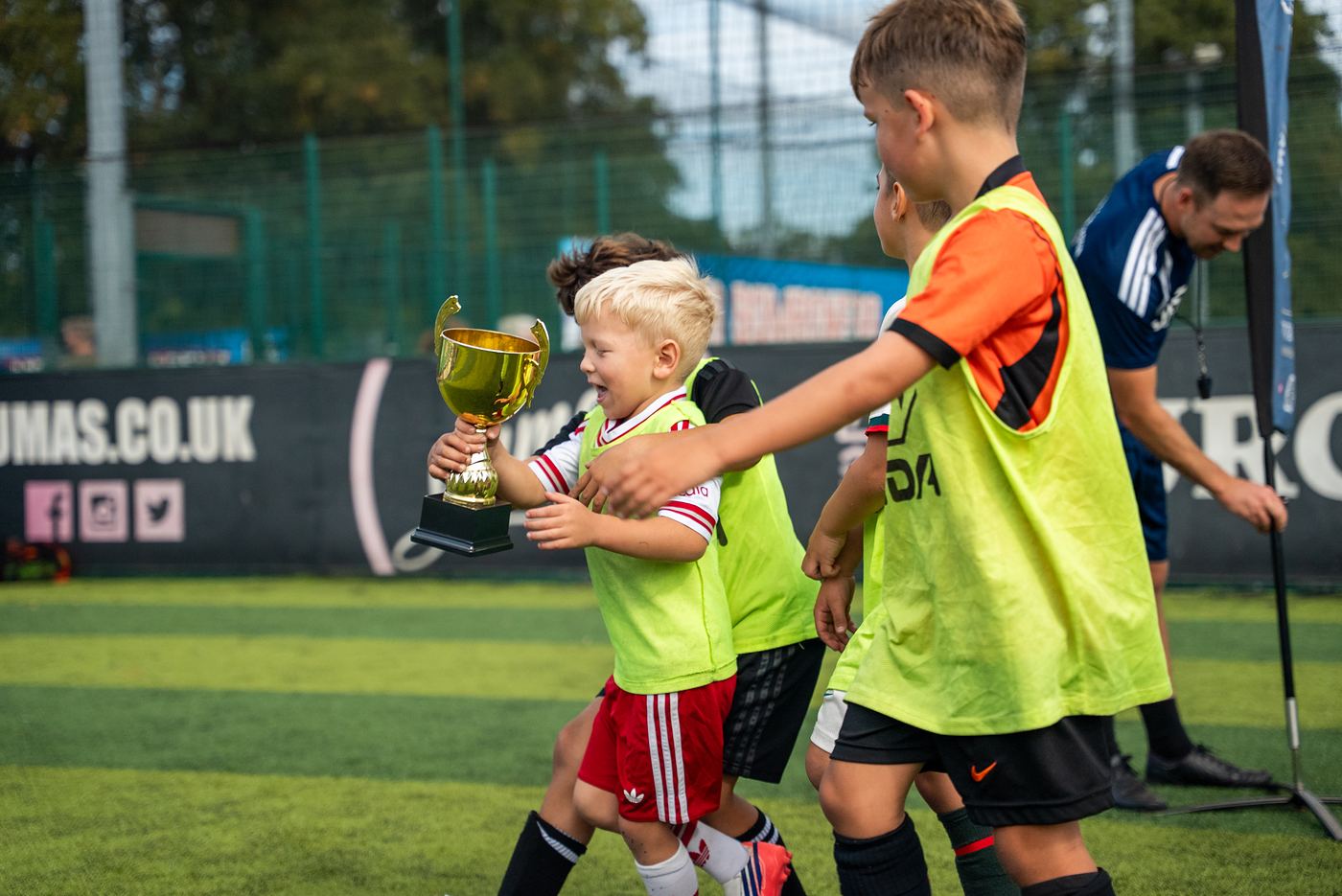 A young player celebrating with the trophy