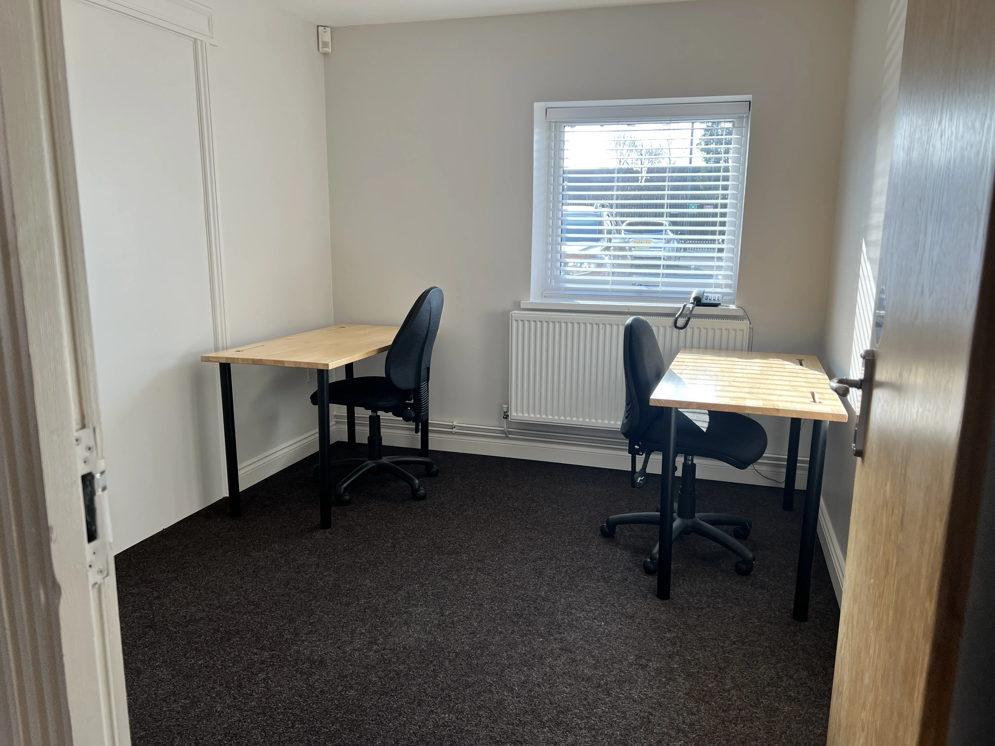 Office 202 at the Maggie O'Neill Centre set with two desks and two chairs by the window