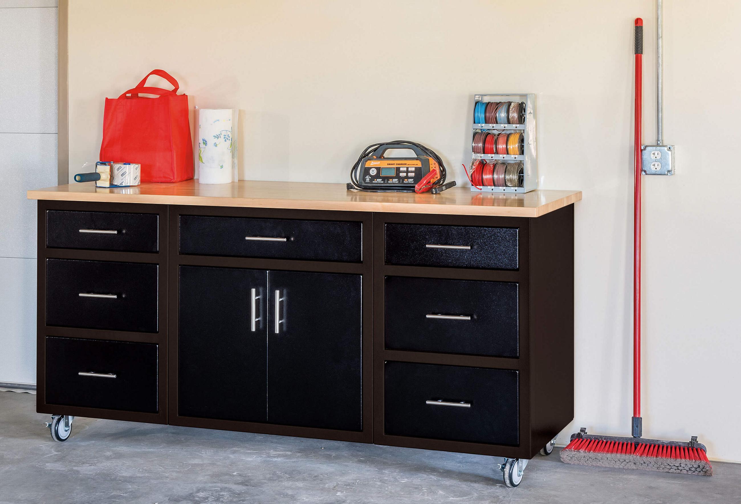 Black aluminum base cabinets with a walnut top on locking wheels in a garage