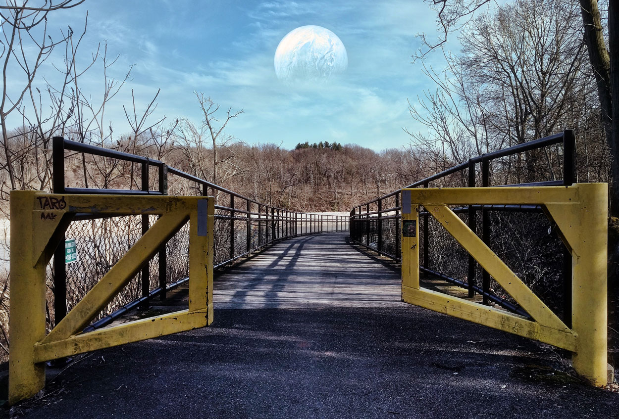 Photo of yellow gates open to a path, blue sky and large pale moon centered within it