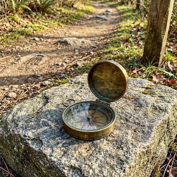 Compass beside a trail representing guidance and personal discernment.