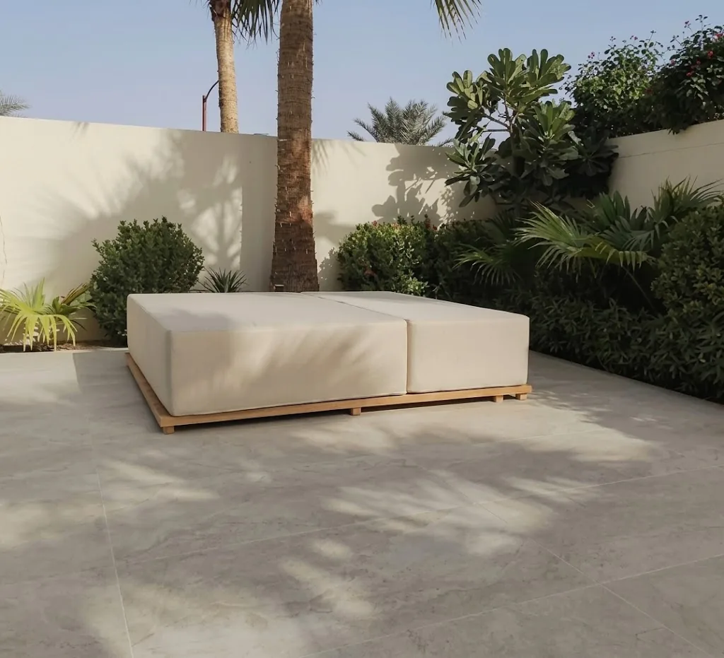 Outdoor daybed with cream covers in a garden
