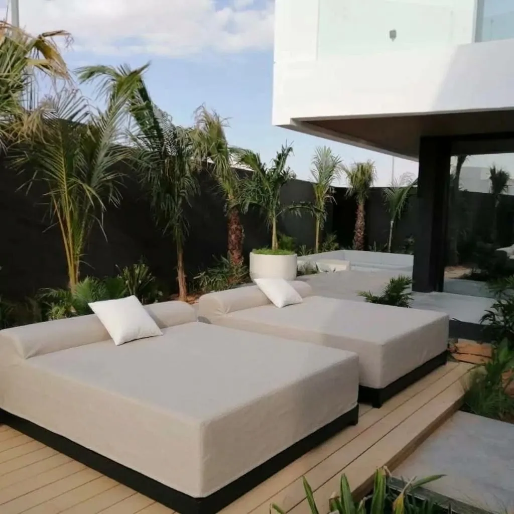 Outdoor daybeds with cream cushions on a deck