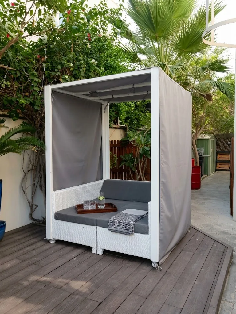 Outdoor cabana with grey cushions and side curtains