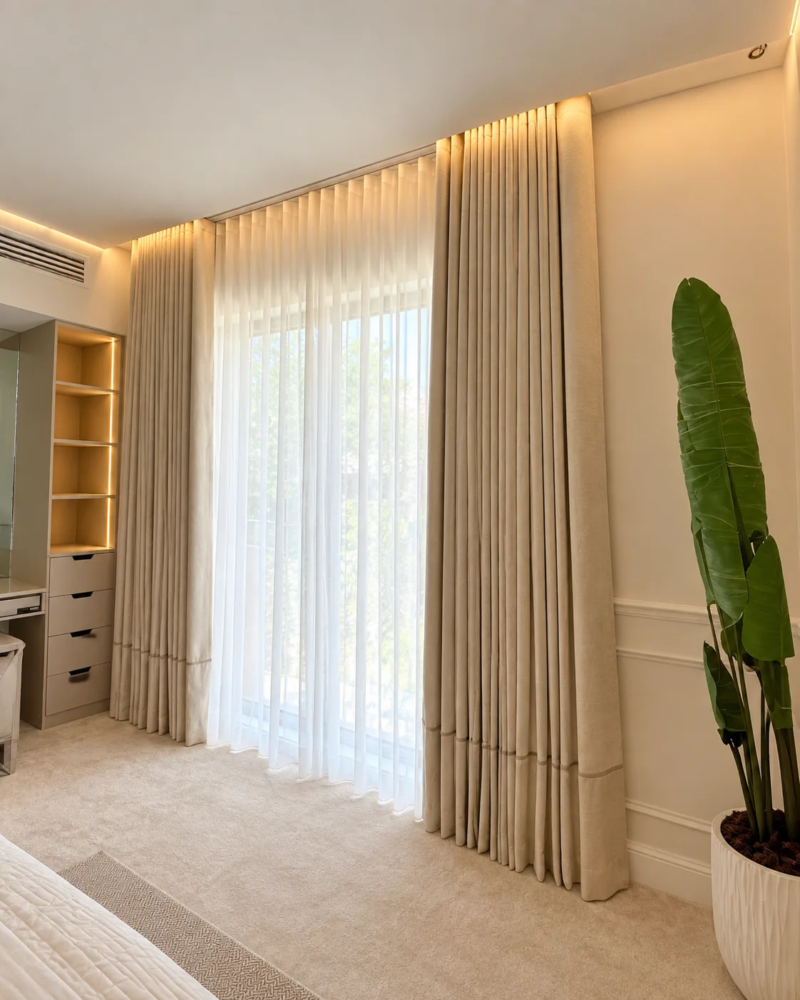 Beige wave curtains and sheers under cove lighting