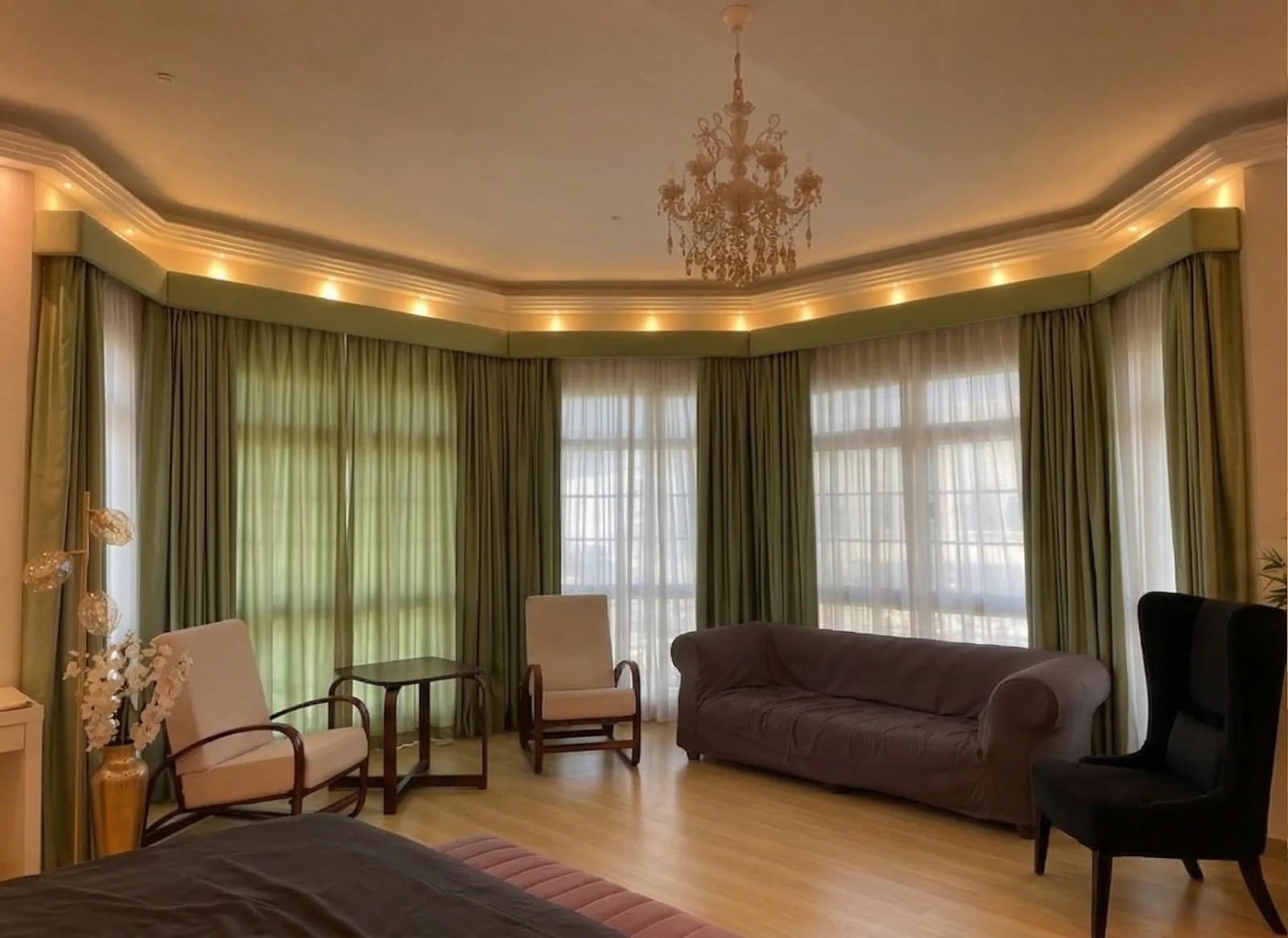 Green pleated curtains and sheers around a wide majlis bay window
