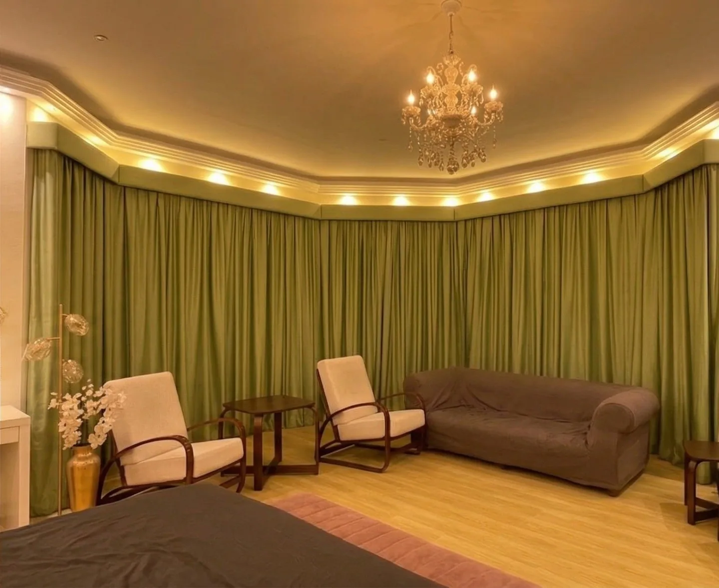 Green pleated curtains with pelmets around a majlis bay window