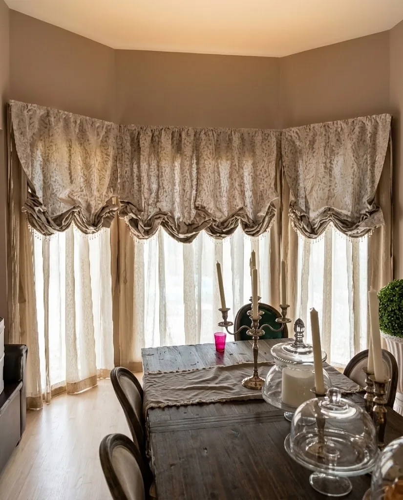 Austrian festoon curtains around a dining room bay window