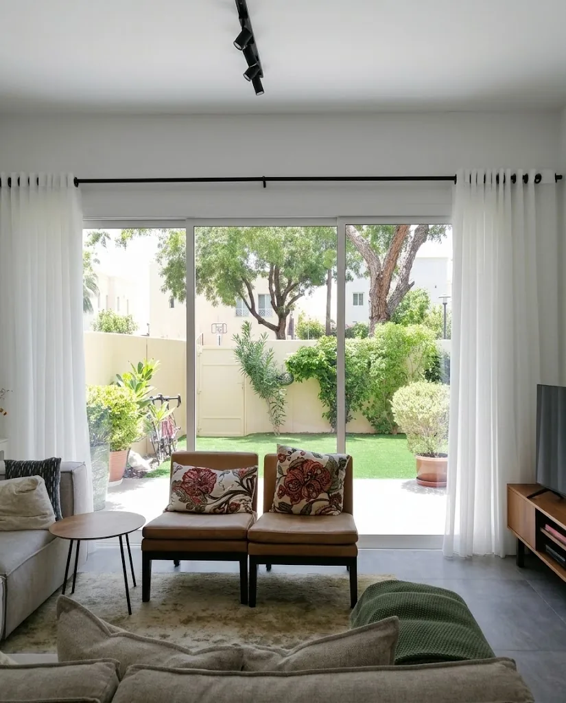 White eyelet sheer curtains across living room doors to the garden