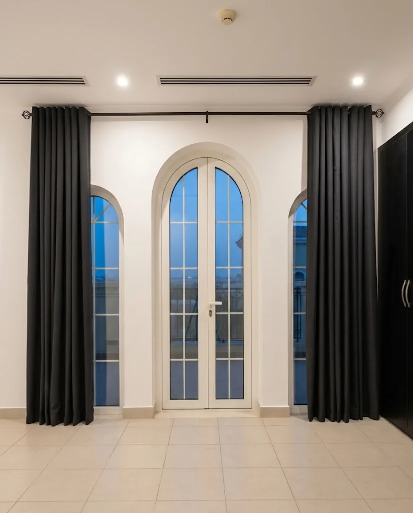 Charcoal eyelet curtains framing arched French doors
