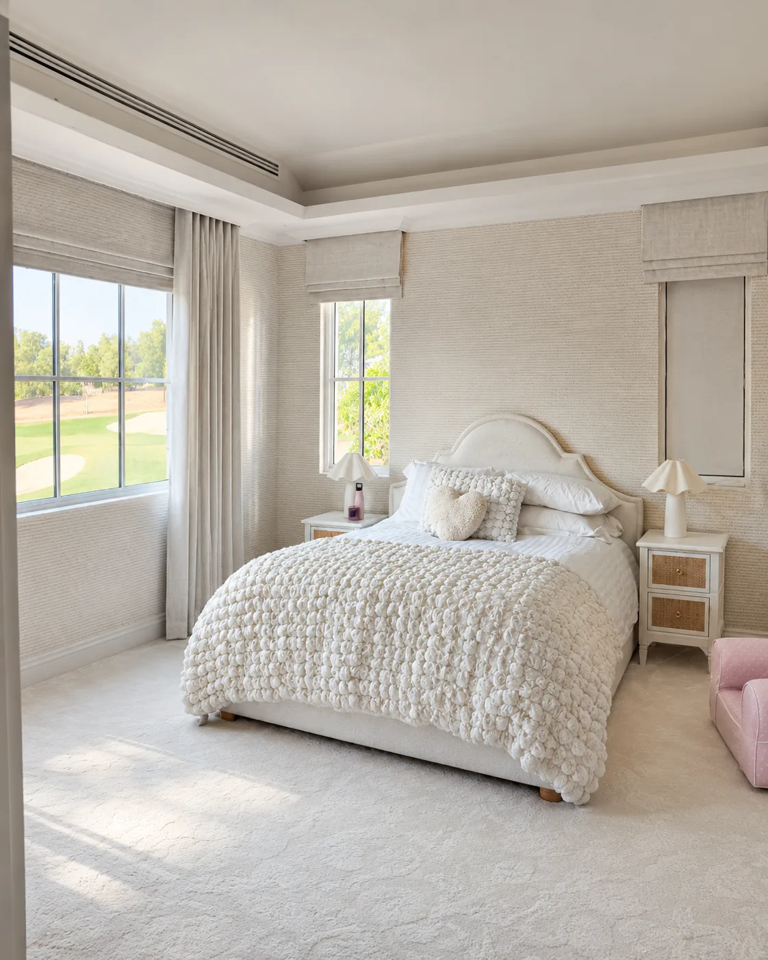 Cream Roman blinds in a bedroom overlooking a golf course