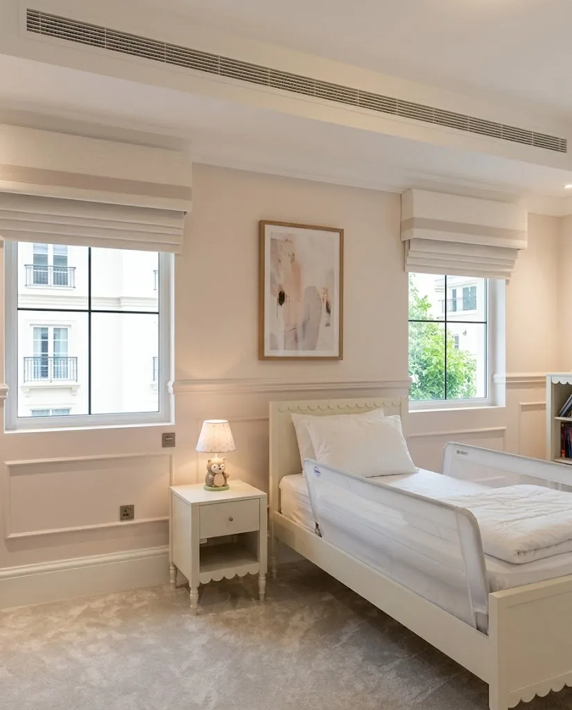 Roman blinds with pink trim in a children's bedroom