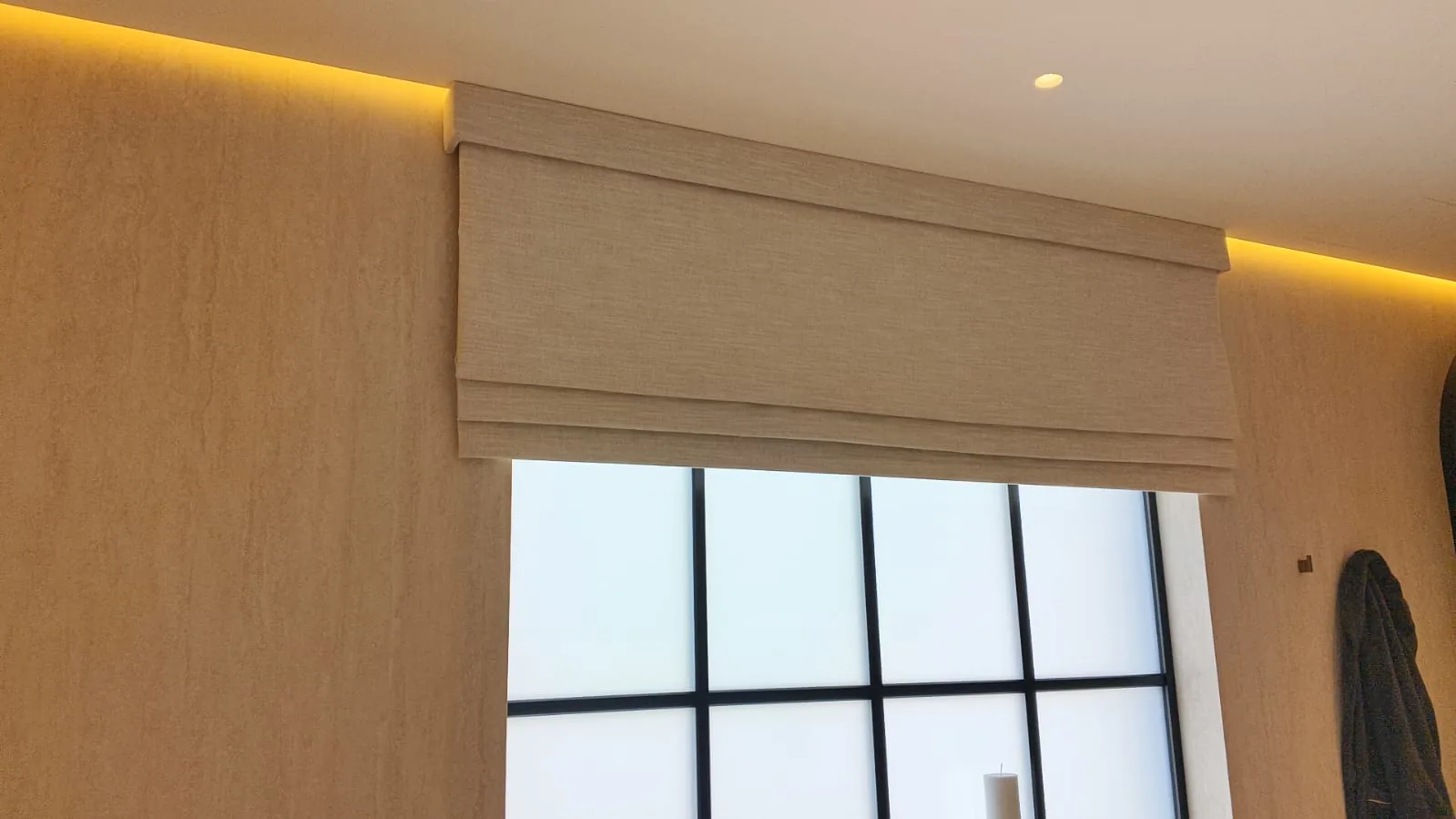 Beige Roman blind under cove lighting