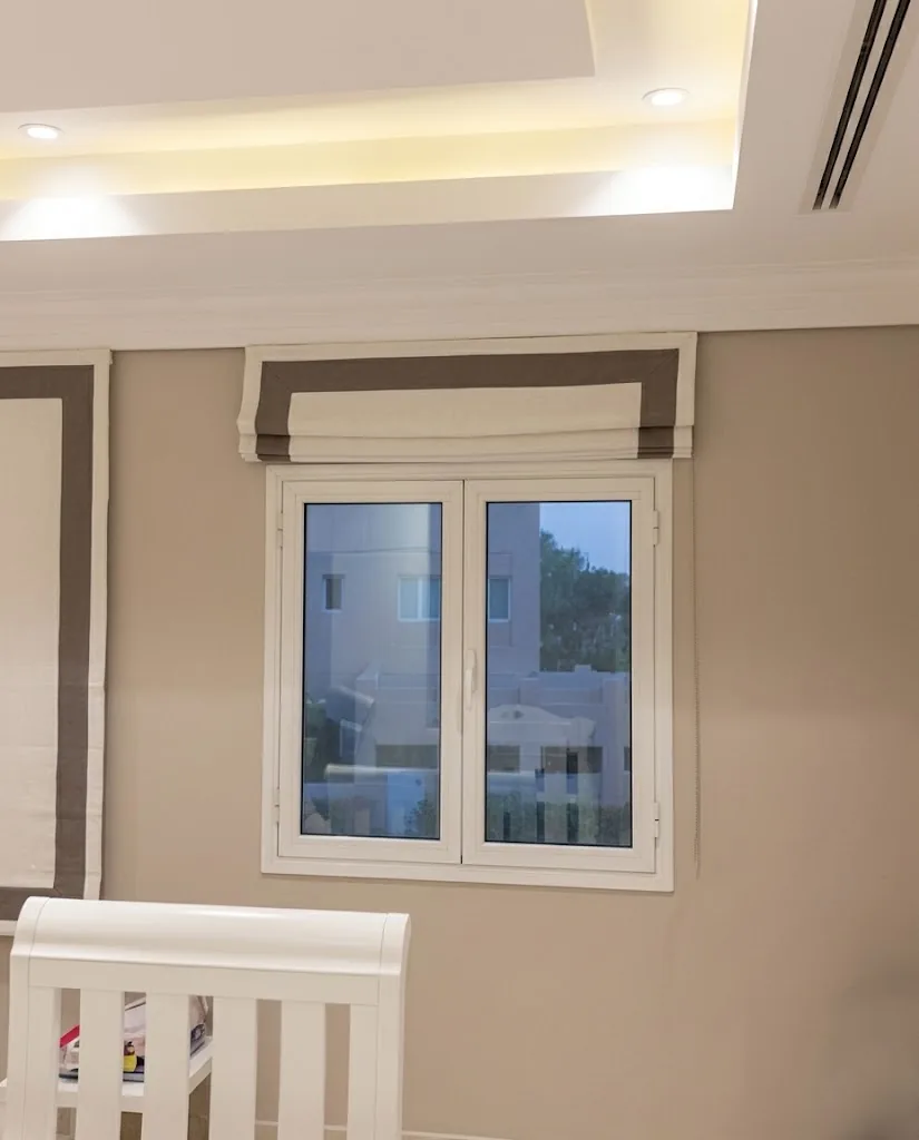 Beige Roman blind with a contrast border in a nursery