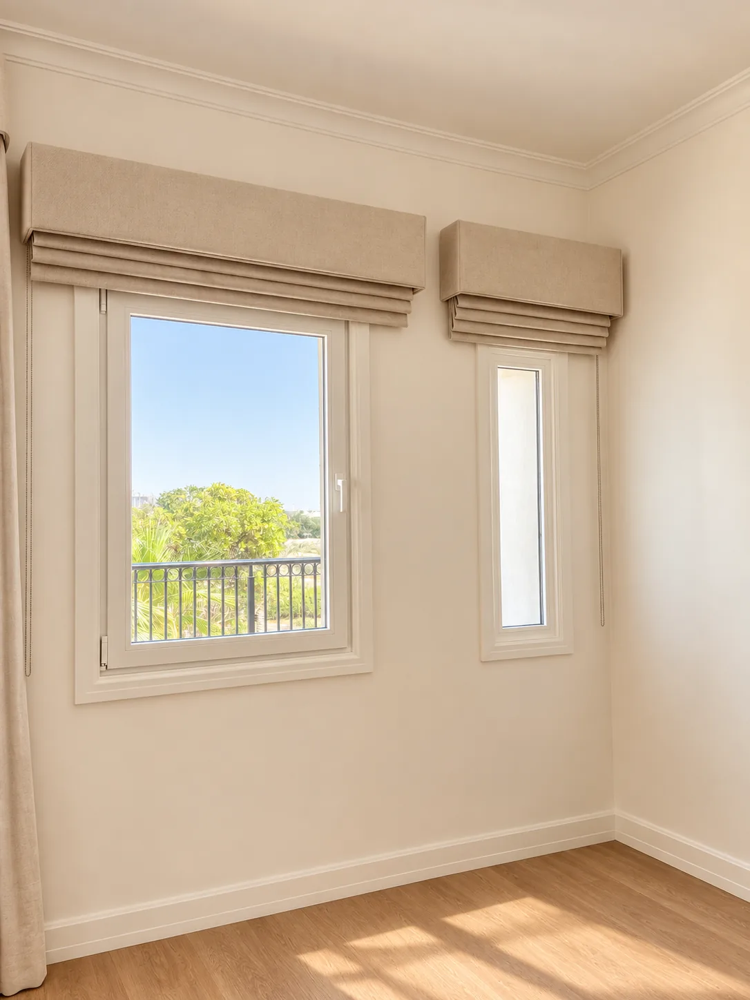 Two beige Roman blinds on a bedroom window and a narrow side window