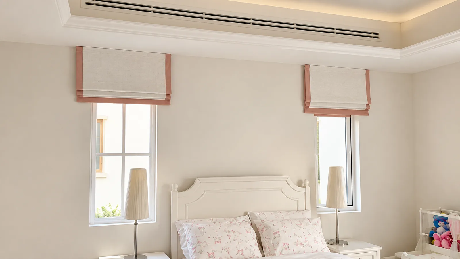 Roman blinds with pink trim in a bedroom