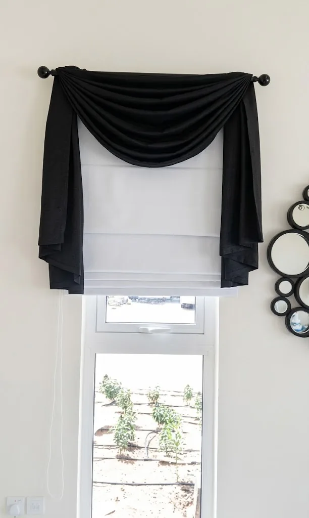 White Roman blind with a black swag valance