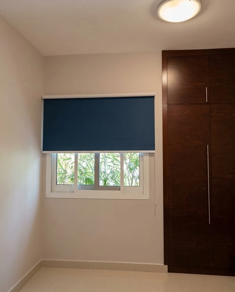 Navy roller blind on a bedroom window