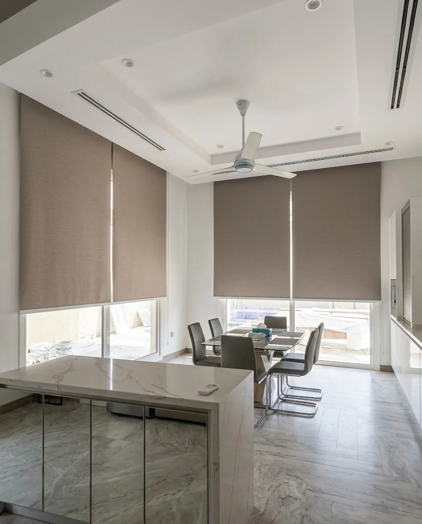 Taupe roller blinds on dining area windows