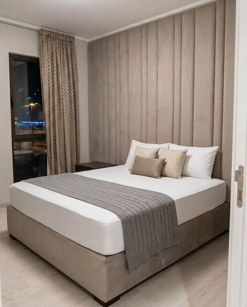 Taupe velvet wall panels behind an upholstered bed
