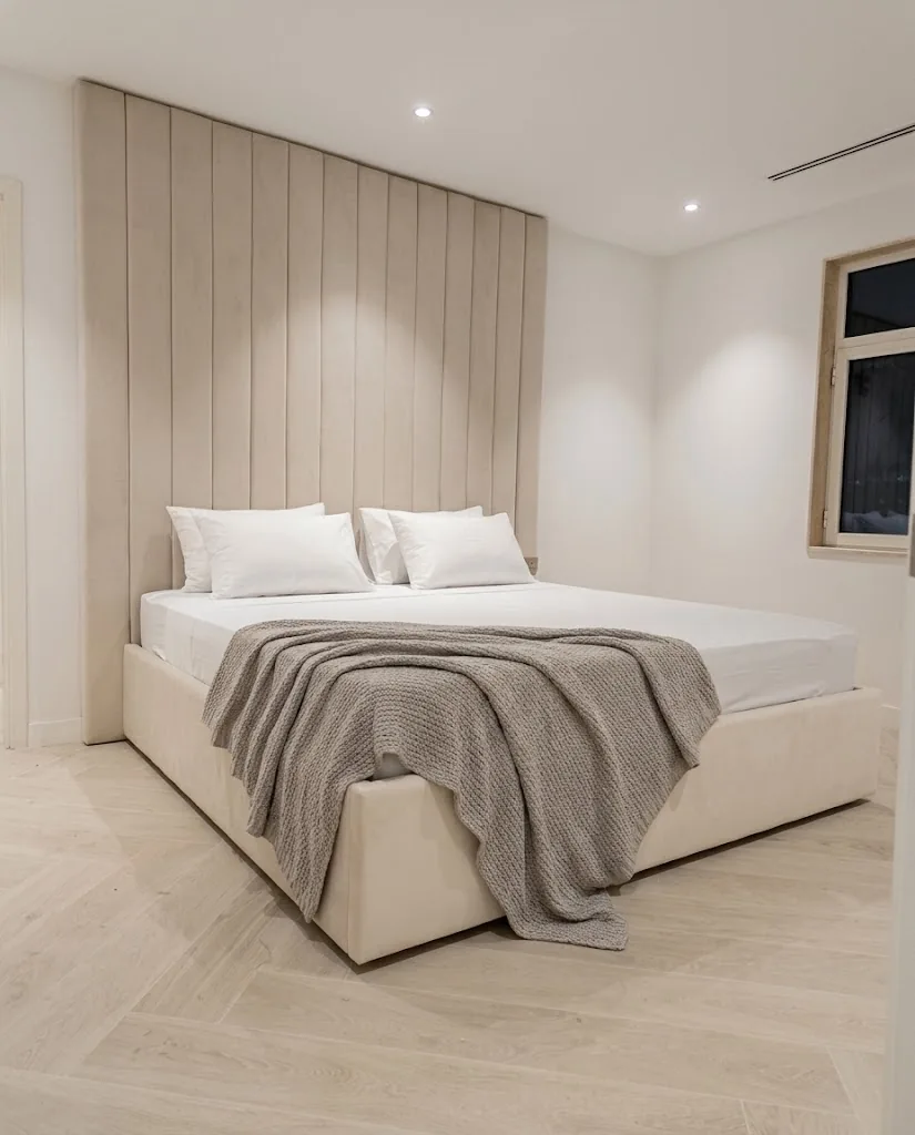 Cream floor-to-ceiling channel headboard behind an upholstered bed