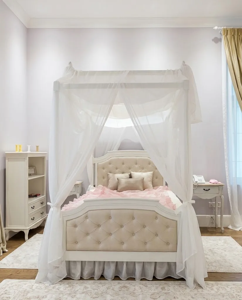 Canopy bed with a button-tufted beige headboard in a girl's bedroom