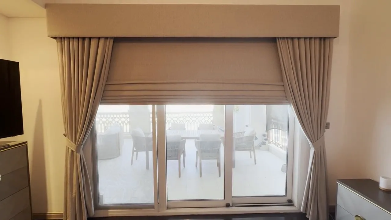 Motorised Roman blind lowered under a fabric pelmet between side curtains