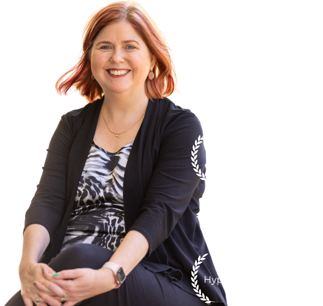 Sharon a woman with red hair wearing a black suit jacket and a zebra shirt. Australian physiotherapy of the year 2024, leader of an ehlers danlos society core network clinic, treating hypermobility for twenty plus years.