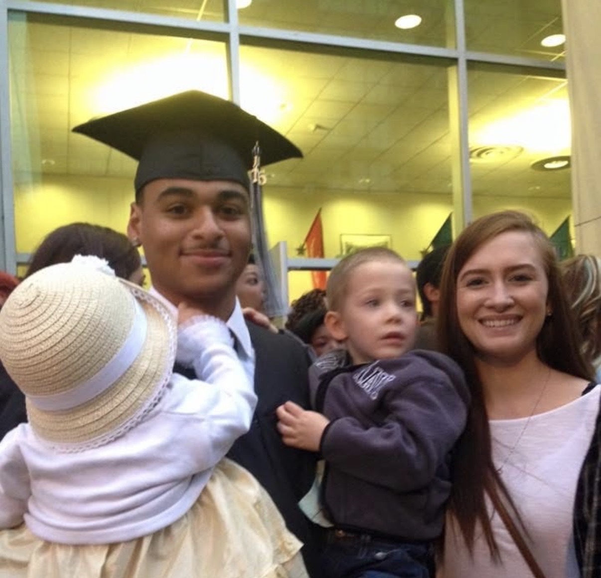 Carlos and Courtney at high school graduation with their two babies