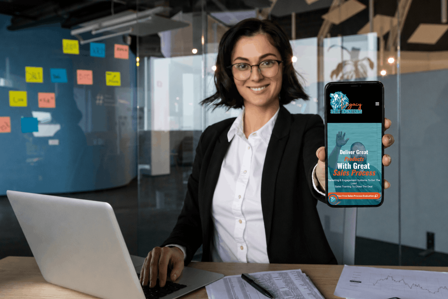 A professional woman in an office setting holds up a smartphone displaying the Legacy Sales Engineering website, showcasing sales process services in Phoenix, AZ. A professional woman in an office setting holds up a smartphone displaying the Legacy Sales Engineering website, showcasing sales process services in Phoenix, AZ.