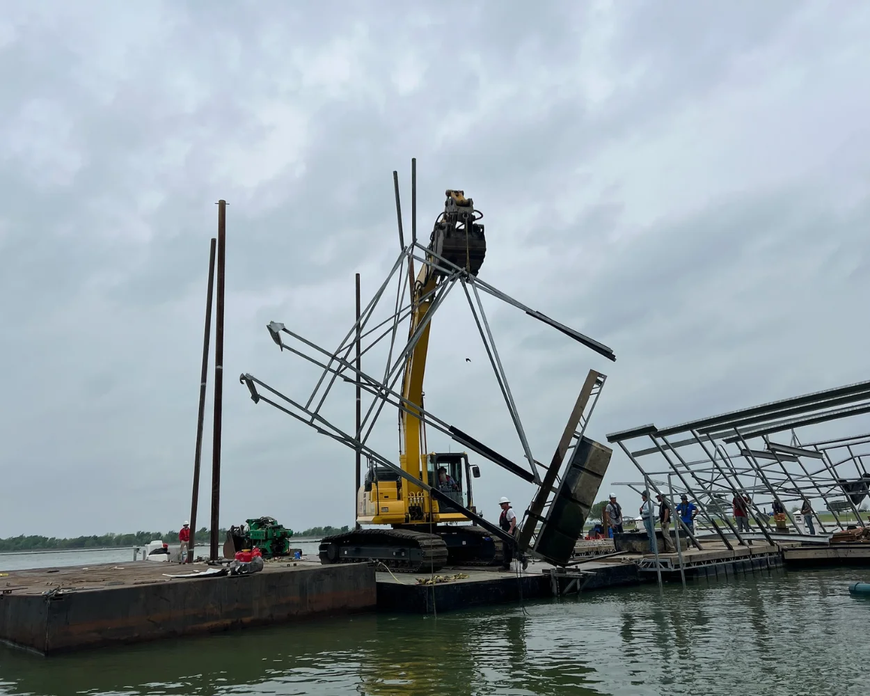 Excavator lifting a damaged portion of a dock