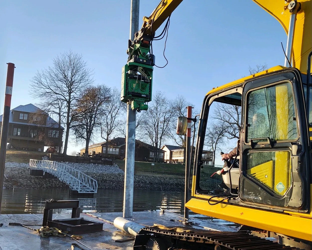 Excavator pile driving on a dock