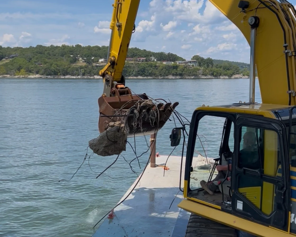 Excavator pulling rubble out of the water