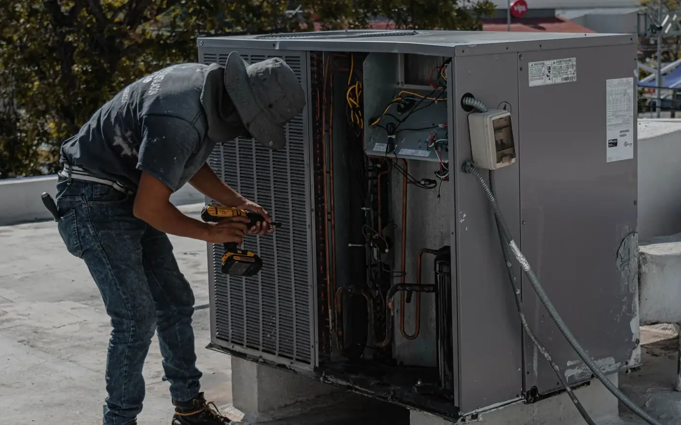 Technician servicing an open packaged rooftop HVAC unit