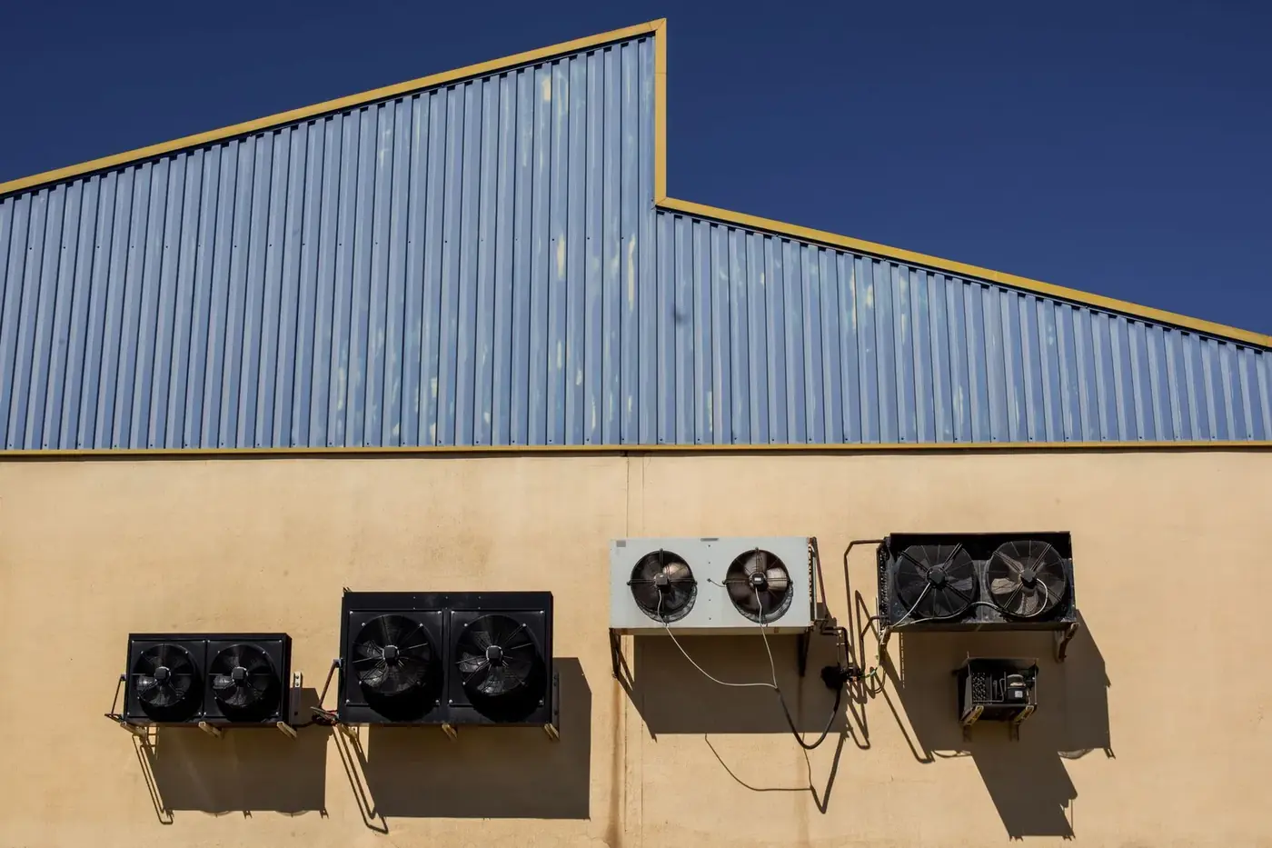Commercial refrigeration condensing units mounted on a warehouse wall