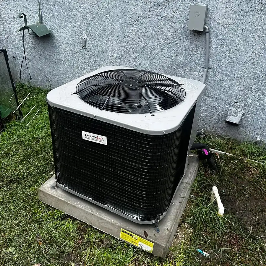 Newly installed outdoor AC condenser on a concrete pad beside a home