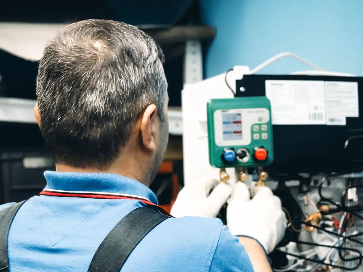 HVAC technician reading a digital refrigerant gauge during a service call