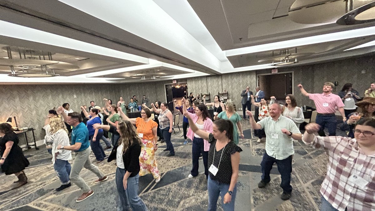 Guests joining a line dance experience at an off-site ballroom event.