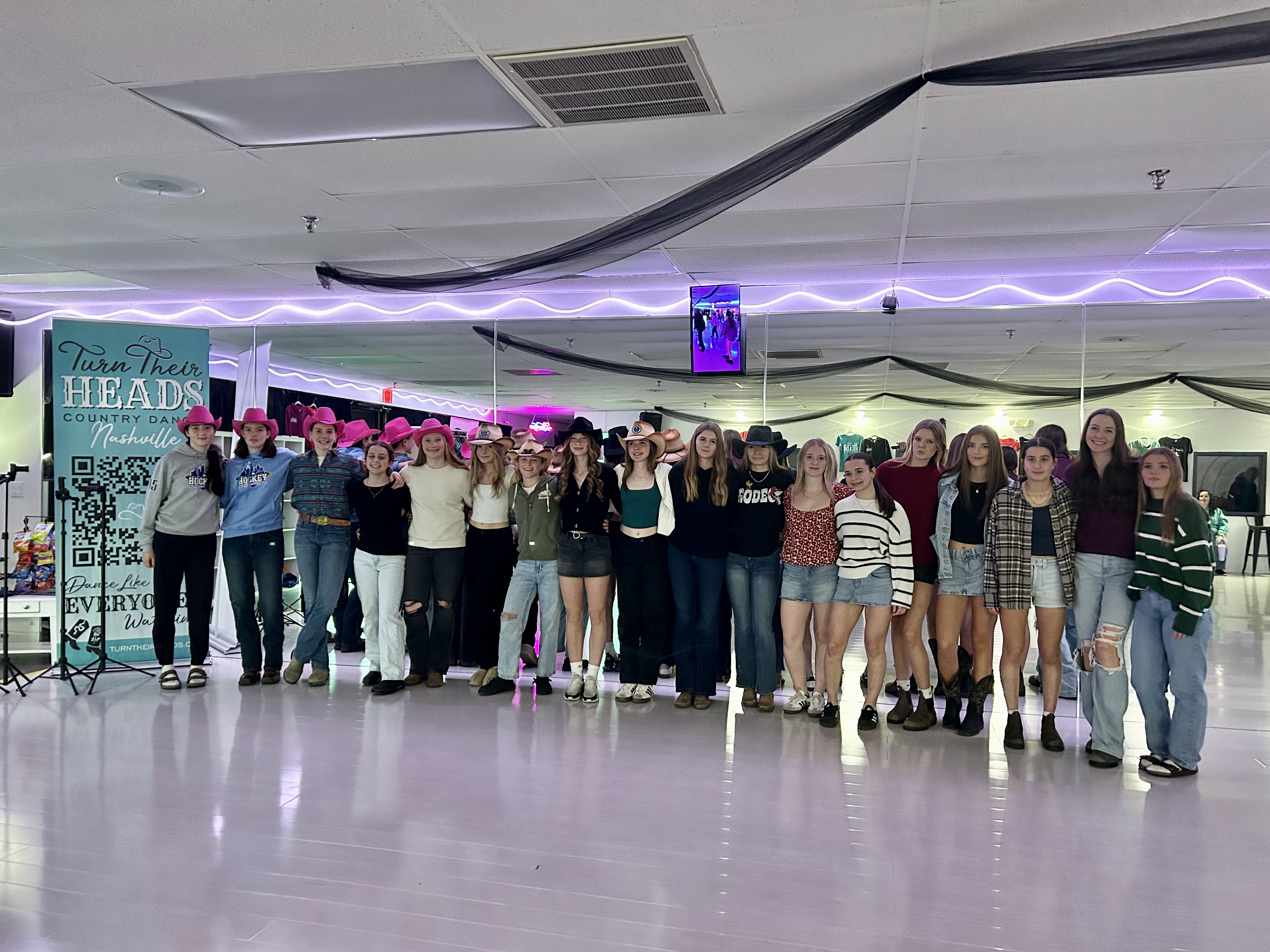 A girls hockey team posing together in the Nashville studio.