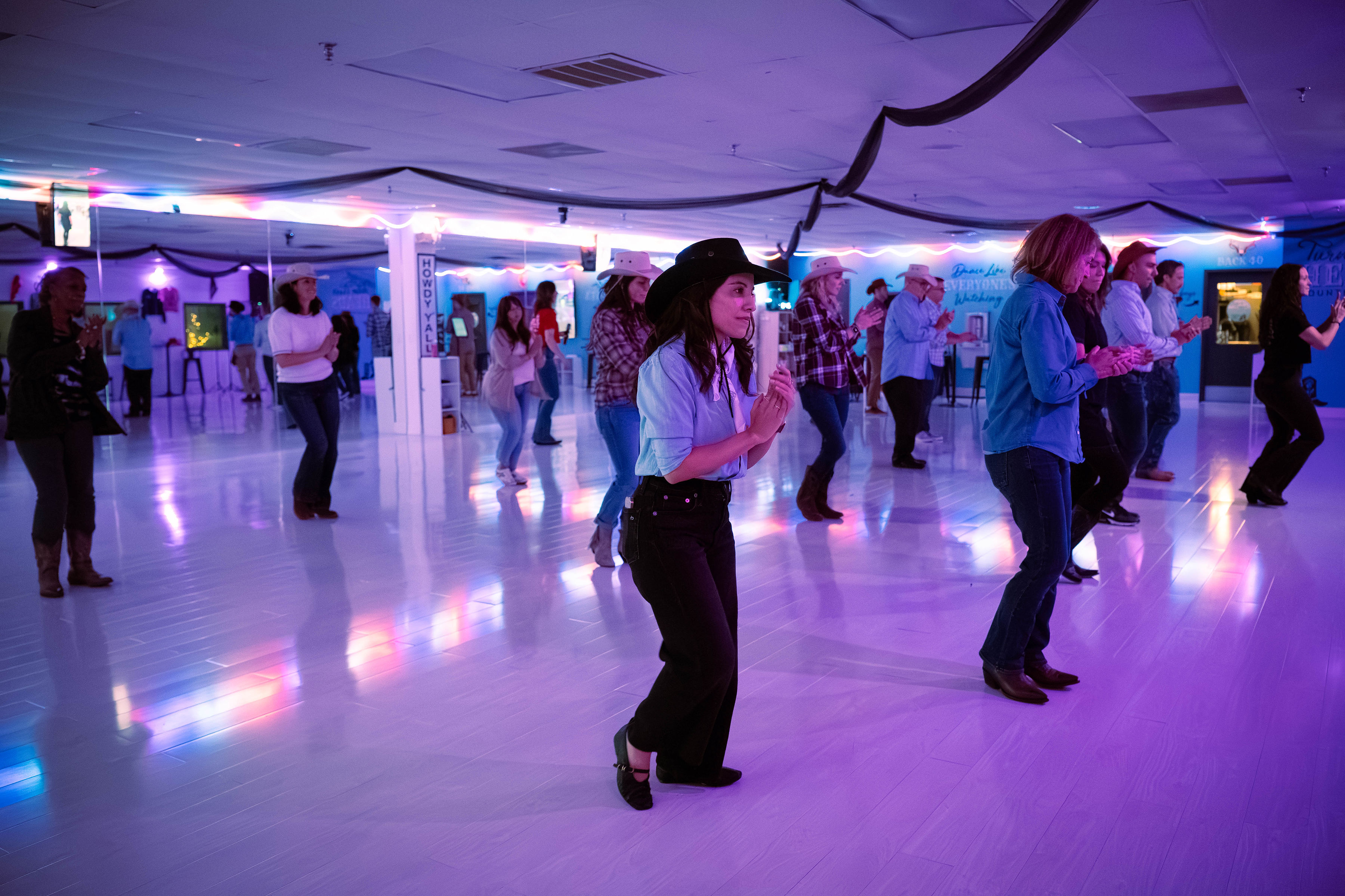 Guests clapping and learning a line dance together in the Nashville studio.