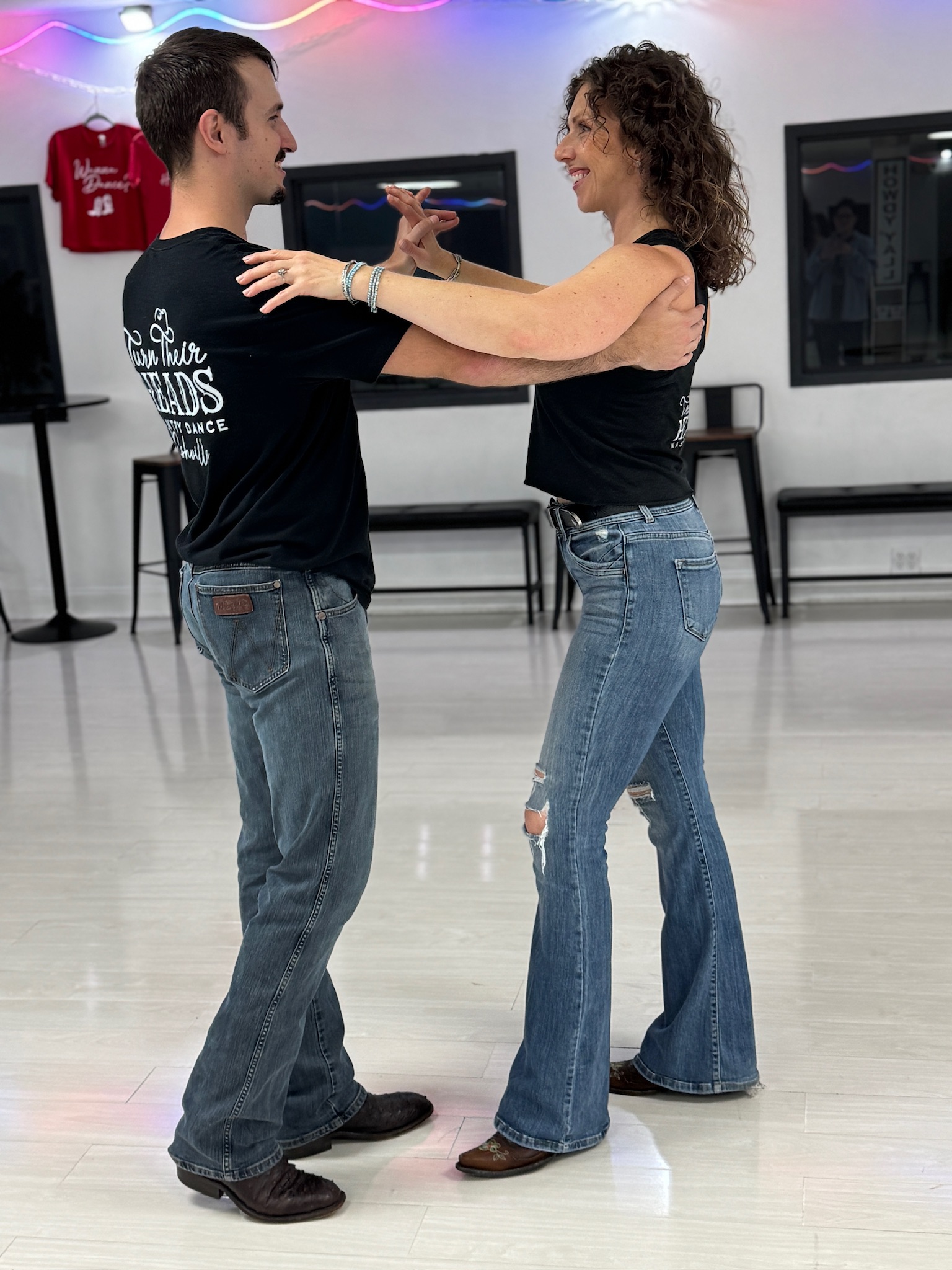 Two dancers smiling in a closed Two-Step position at the studio