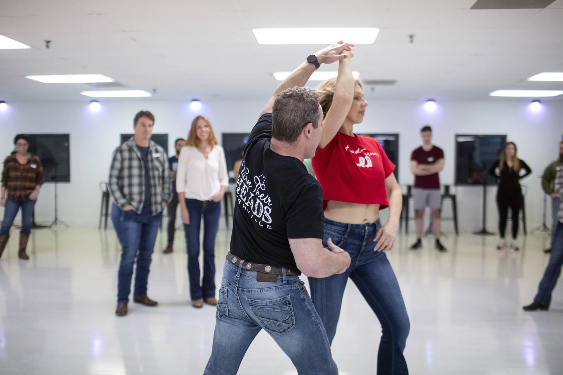 An instructor guiding a Country Swing turn during a studio lesson