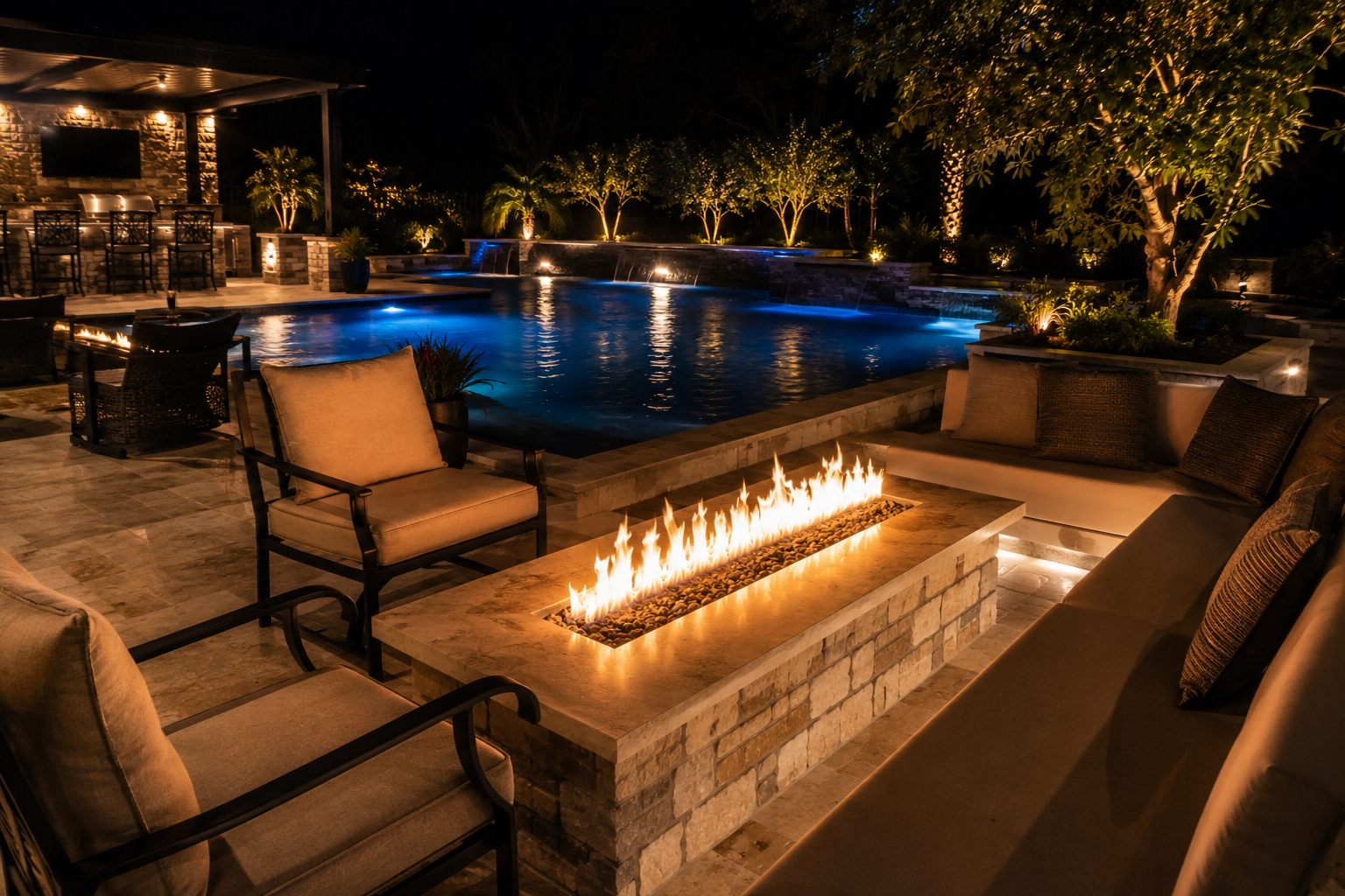 Linear fire pit with seating area near custom gunite pool at night in East Texas backyard
