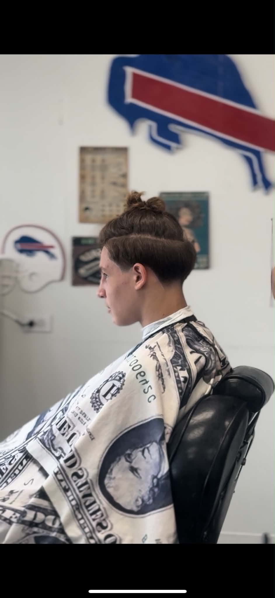 Money-print barber cape in use at Sammi Red's Real Barbers in Kenmore