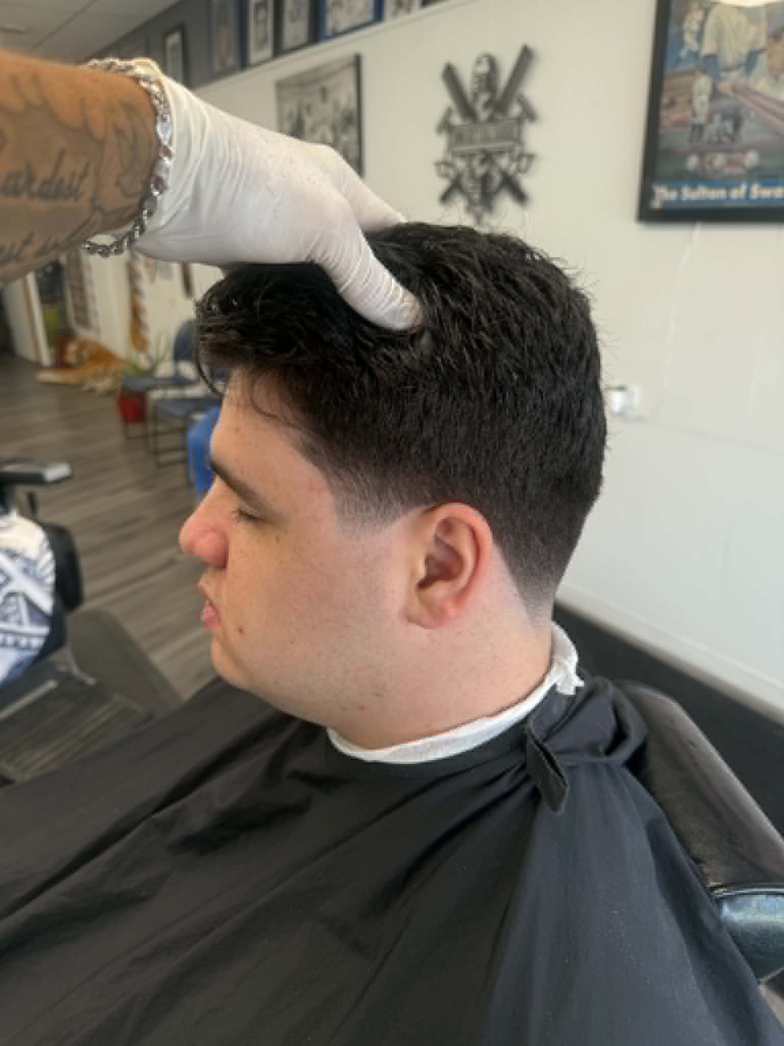 Barber working on a client's haircut at Sammi Red's Real Barbers in Kenmore