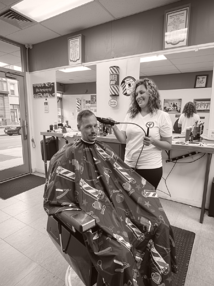 Owner Samantha Rosso cutting a client's hair at Sammi Red's Real Barbers in Kenmore, NY