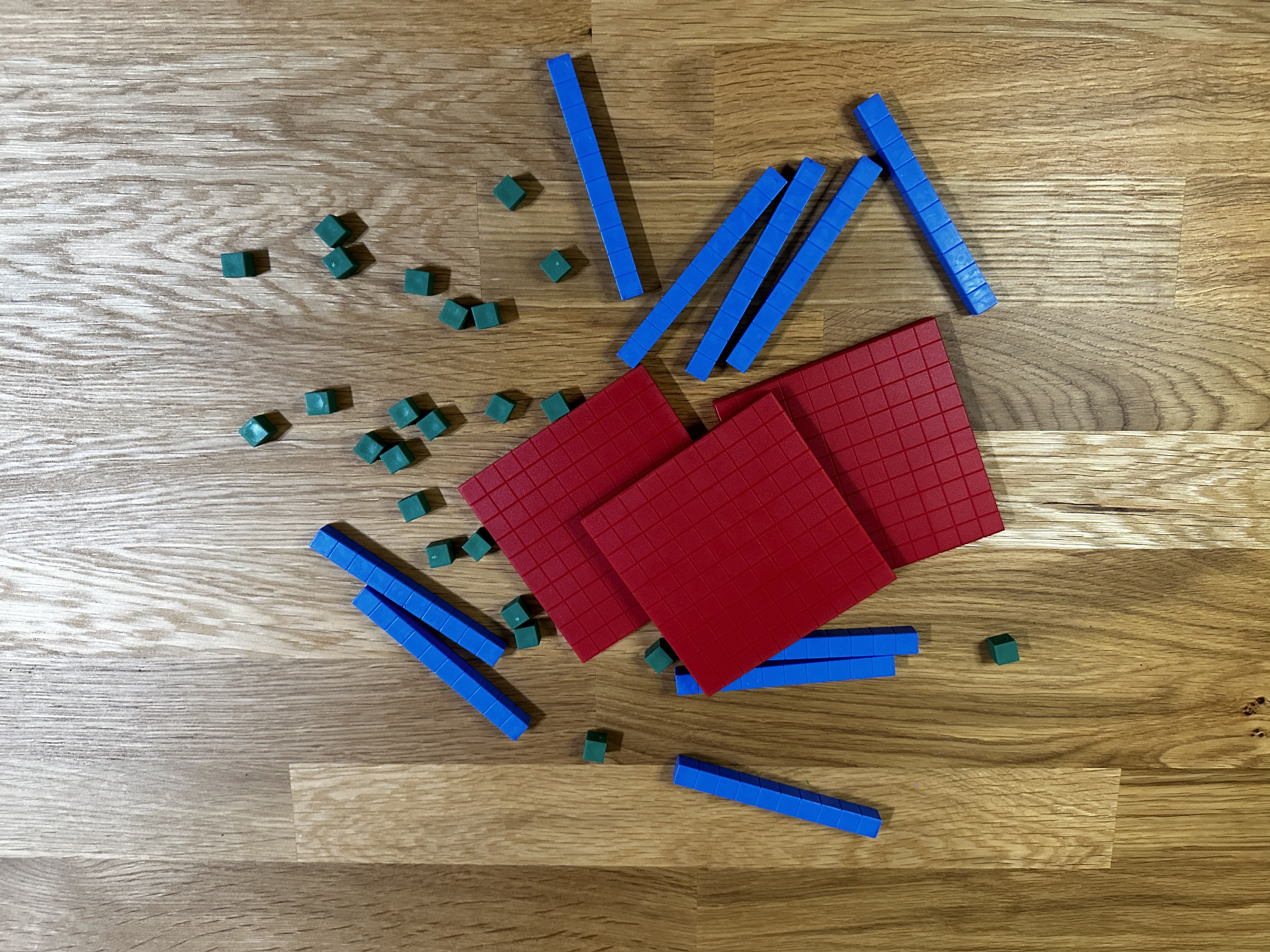 Base ten blocks scattered on a wooden desktop illustrating math manipulatives used as accommodations for students with dyscalculia Base ten blocks scattered on a wooden desktop illustrating math manipulatives used as accommodations for students with dyscalculia